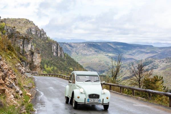 Voir les montagnes de France à travers le pare-brise classique et nuageux d'une Citroën
